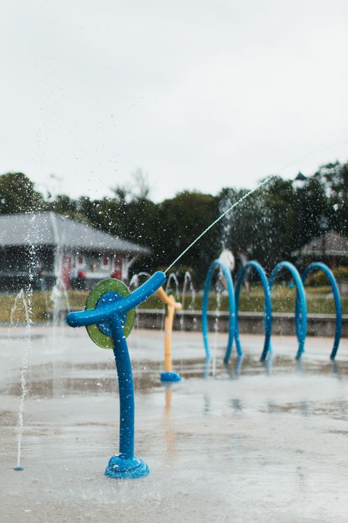 Colorful splash pad water jets over a wet recreational surface