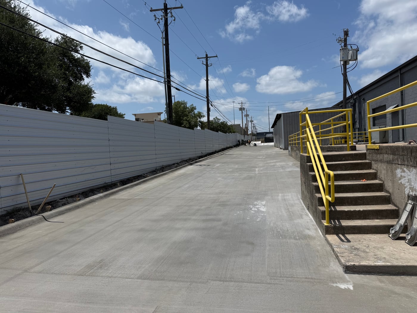 Commercial concrete paving with curb and retaining walls along an industrial drive