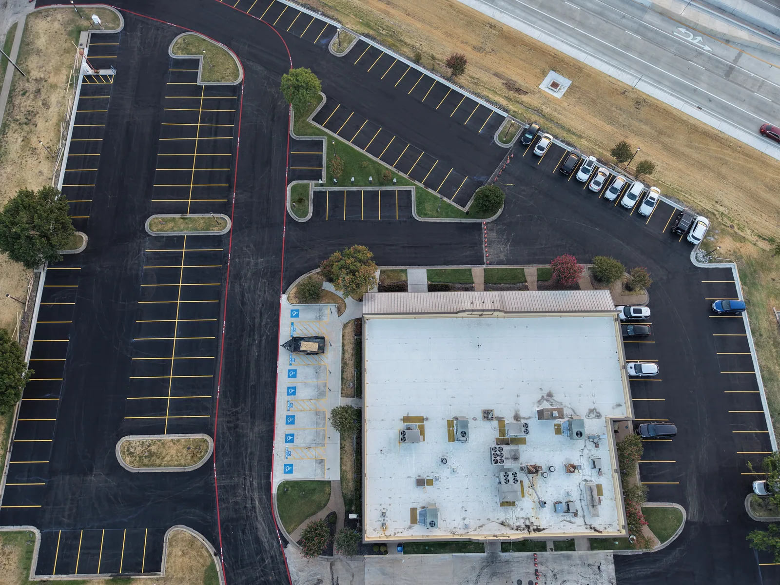 Completed commercial asphalt parking lot with fresh striping and fire lanes