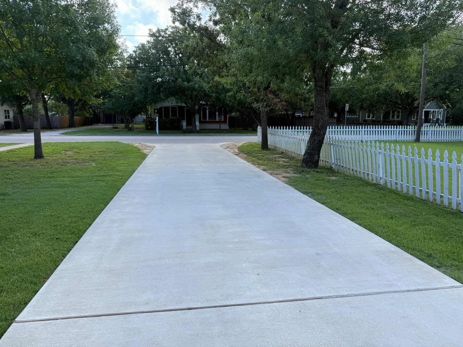 Long finished concrete pedestrian access route through a landscaped area