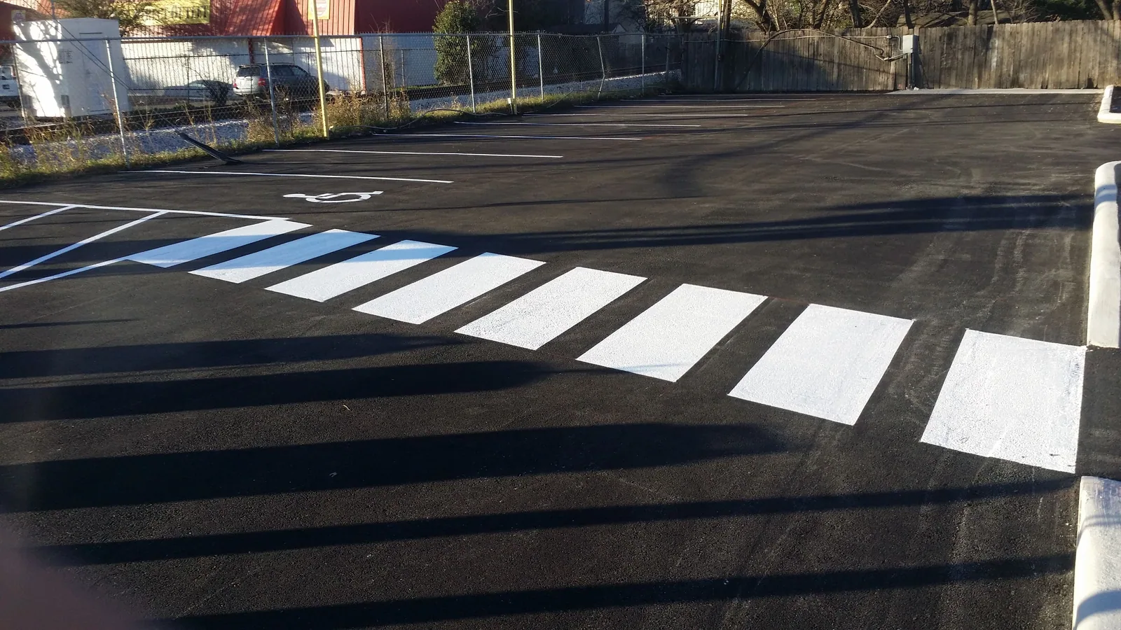 Fresh ADA stall and crosswalk markings on asphalt